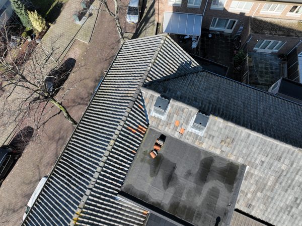 Plat dakdeel met dakranden en doorvoeren bij een wooncomplex