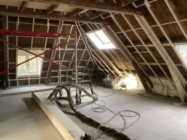 Houten dakconstructie met steiger en dakraam tijdens het isolatiewerk