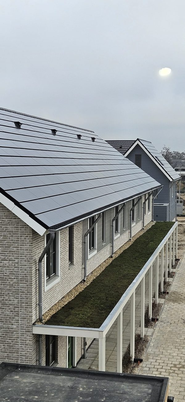 Geïntegreerde zonnepanelen en dakafwerking langs een rij woningen