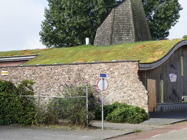 Groen dak op een gebouw met een gebogen dakrand